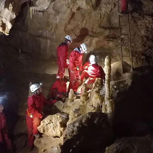 Groupe de spéléologues au fond de la grotte roche
