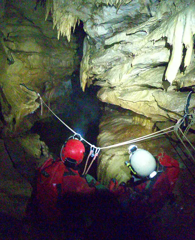 deux personnes dans une grotte, pratiquant la spéléologie