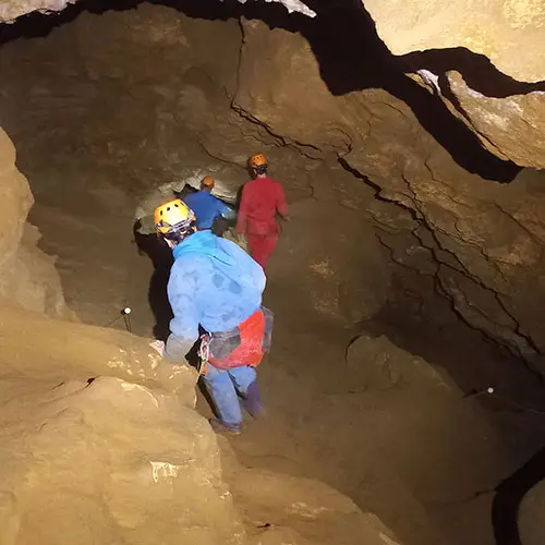 Groupe de personnes pratiquant la spéléologie dans une grotte à Jujurieux